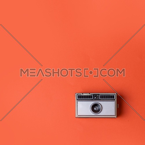 Old vintage Photo Camera on a orange Background