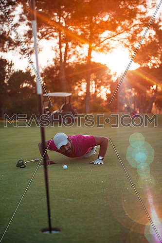 golf player blowing ball in hole. concept of cheating and success, beautiful sunset in backgrund