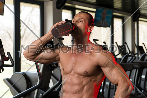 Muscular Mature Man Drinking A Water Bottle