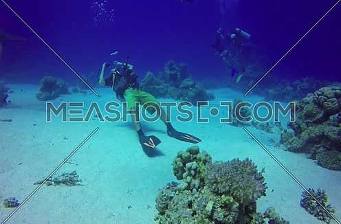long shot for scuba divers underwater playing with bubbles at The Red Sea