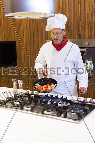 Senior middle east chef's fried meal in the kitchen with satisfaction