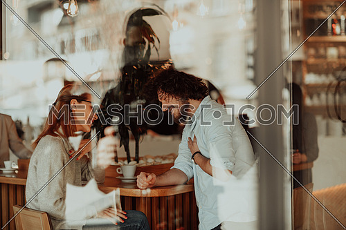 a woman in glasses and men with afro hair sit in a cafe and talk about business projects