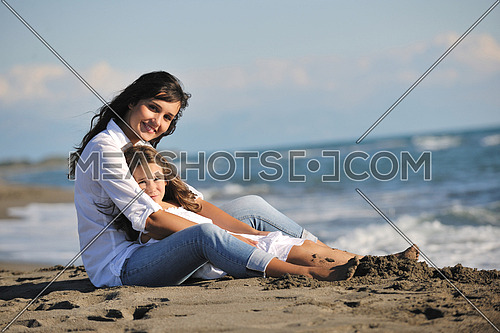 family portrait of young beautiful mom and daughter on beach