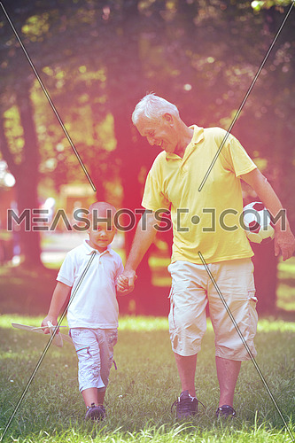 happy grandfather and child have fun and play in park