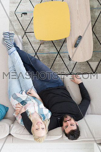 top view of Young couple on the sofa watching television together at home