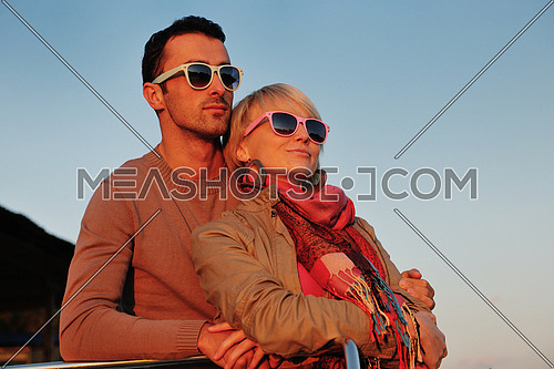 happy young couple in love  have romantic time at summer sunset   at ship boat while  representing urban and countryside fashin lifestyle