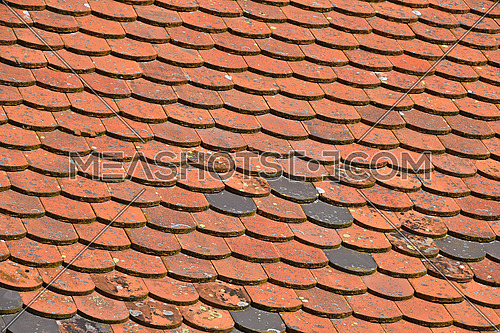 Old weathered vintage traditional red brown ceramic roof tiles pattern background, close up, low angle side view