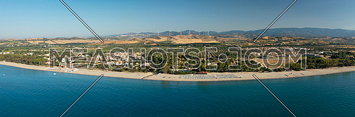 Panoramic view of the Calabria coastline, mediterranean sea,beach,agricultural fields and wind turbines in the background, Calabria, Italy.