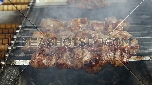 Close up of cooking shashlik shish kebab beef Churrasco style meat on grill metal skewers, high angle view