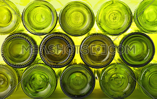 Close up stack of many empty washed green glass wine bottles bottom side, low angle view