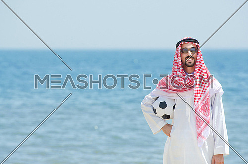 Arab with footbal at seaside