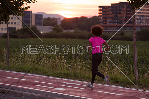 young beautiful African American woman enjoys running outside beautiful summer evening in the city