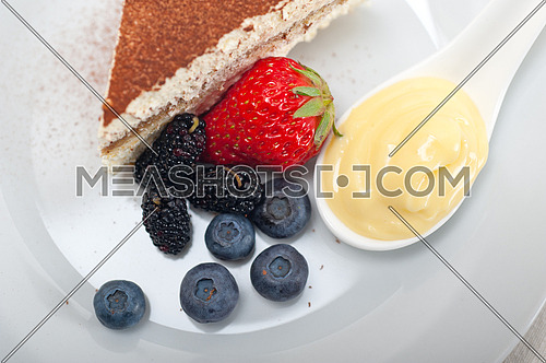 classic Italian tiramisu dessert with berries and custartd pastry cream on side