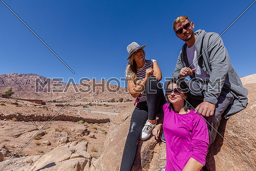 long shot group of tourists standing while exploring Sinai Mountain for wadi Freij at day.