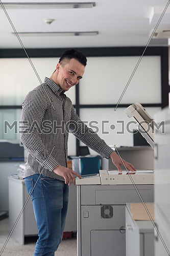 young business man copy documents on copy machine at modern startup office interior, casual clothes