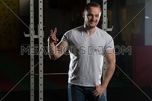 Smiling Man Showing Peace Sign In Gym