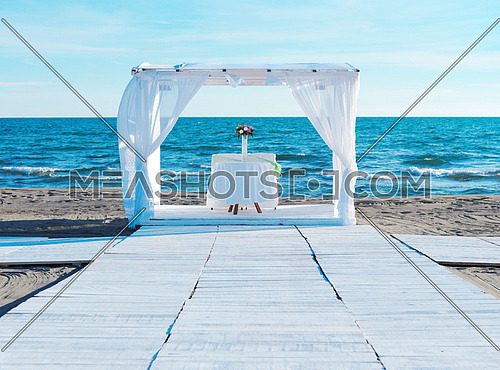 romantic white wedding table set up on tropical beach