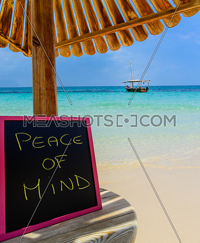 In the picture a Zanzibar beach which is a small blackboard with the words \