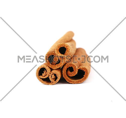Close up heap of three cinnamon sticks isolated on white background, low angle view