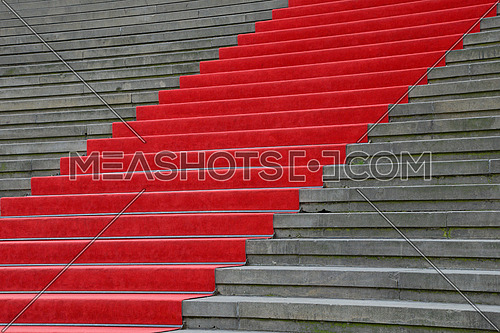 Close up red carpet over grey concrete stairs perspective ascending, low angle view