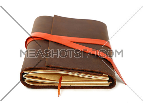 Close up of one vintage style jotter notebook with old leather cover and orange bookmark strap, isolated on white, low angle view