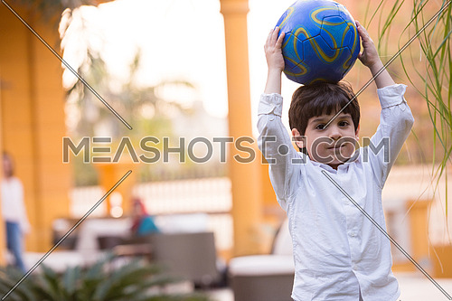 portrait of middle eastern boy with a ball sunny summer day in the yard