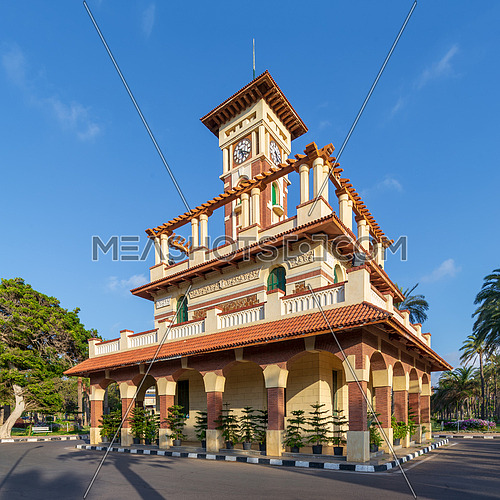 The clock tower in Montaza public park with decorated stone wall, green wooden window shutters, and red tile canopies, Alexandria, Egypt