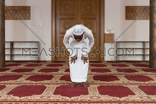 African Muslim Man Making Traditional Prayer To God While Wearing A Traditional Cap Dishdasha