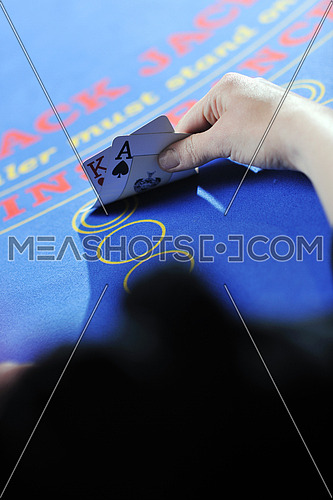 woman play black jack card game in casino on blue table