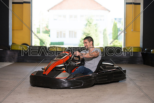 Young Man Is Driving Go-Kart Car With Speed In A Playground Racing Track - Go Kart Is A Popular Leisure Motor Sports