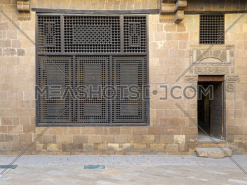 Facade (Mashrabiya window and open wooden door on stone wall) of Beit (house) El Harrawi, an old Mamluk era historic house in Medieval Cairo, Egypt