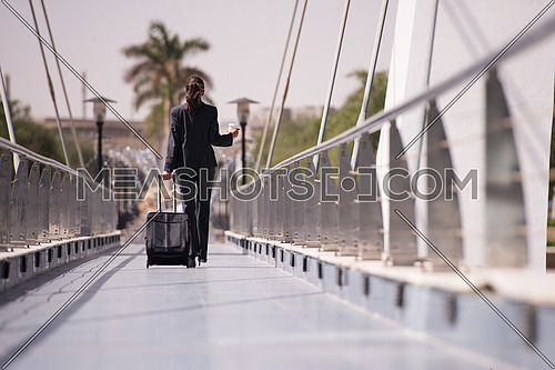 young businesswoman with travel bag and fresh morning coffee walking to catch the plain at  airport