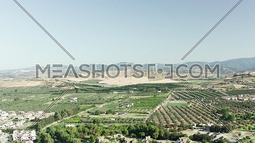 Aerial view of the Calabrian hinterland, olive fields and wind turbines in the background, Calabria, Italy.