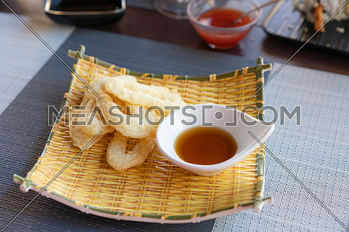 Ika Furai - Deep fried squid rings coated in panko breadcrumbs served with soy sauce and background chili sauce