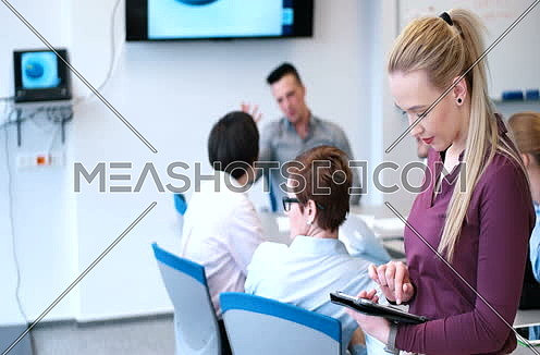 Pretty Businesswoman Using Tablet In Office Building during conference