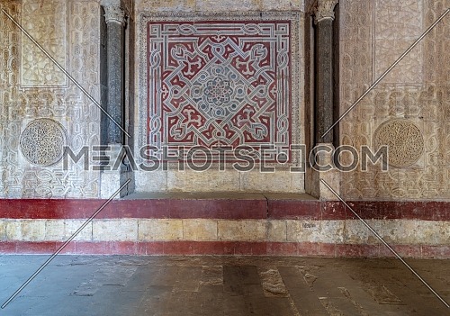 Stone wall decorated with colorful engraved floral and geometric patterns at the entrance of Sultan Hassan public historical mosque, Old Cairo, Egypt