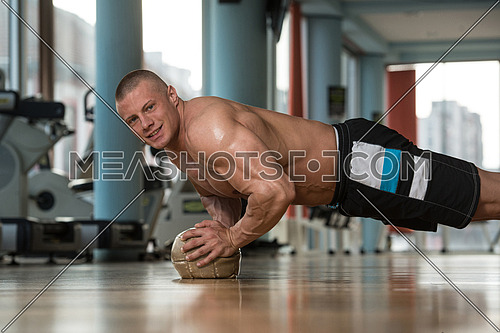 Young Adult Athlete Doing Push Ups On Medicine Ball As Part Of Bodybuilding Training
