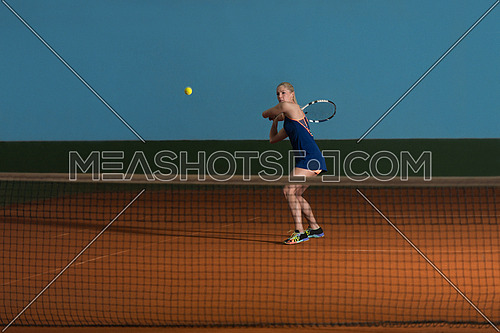 Female Tennis Player Reaching To Hit The Tennis Ball On Court