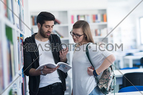 happy students couple in school  library have discussion about book
