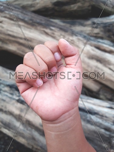 Close-up child hand clenched into a fist when outdoors