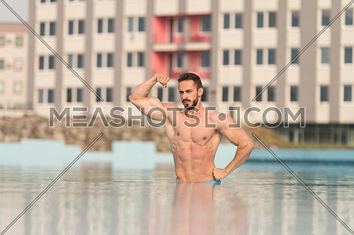 Portrait Of A Very Muscular Sexy Man In Underwear At Swimming Pool Showing Biceps