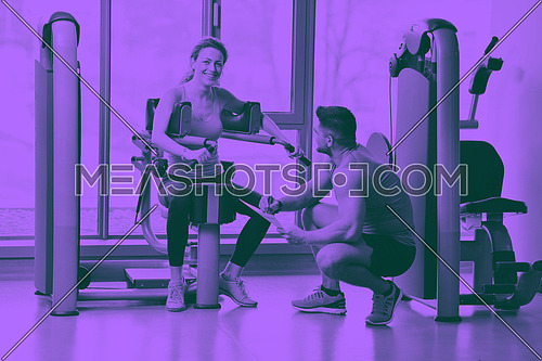 Gym woman exercising with her personal trainer duo tone