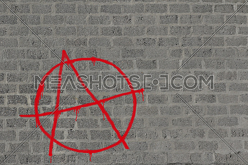 Concrete block wall with anarchy in red sprayed on it in red, illustration for urban background