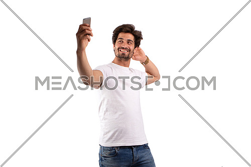 an Egyptian man holding a mobile phone dressed in white shirt and jeans