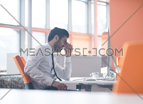 frustrated young business man working on desktop  computer at modern startup office interior
