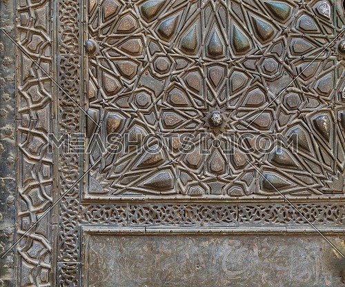 Ornaments of the bronze-plate ornate door of Sultan Barquq mosque, ancient public historic mosque in Old Cairo, Egypt