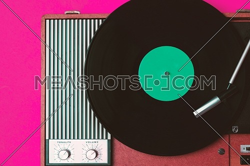 Old vinyl player and turnable on a fuchsia background. Entertainment 70s. Listen to music. Top view.