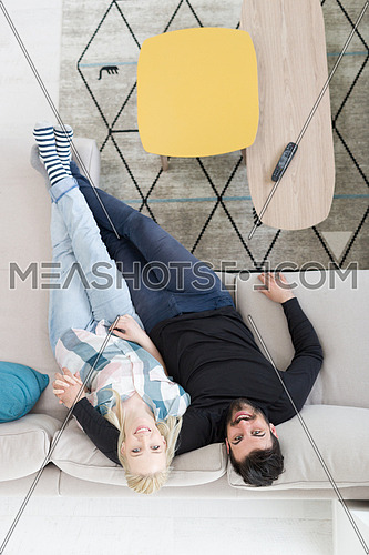 top view of Young couple on the sofa watching television together at home