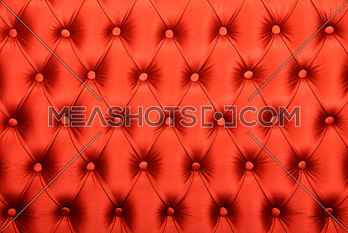 Red capitone textile background, retro Chesterfield style checkered soft tufted fabric furniture diamond pattern decoration with buttons, close up