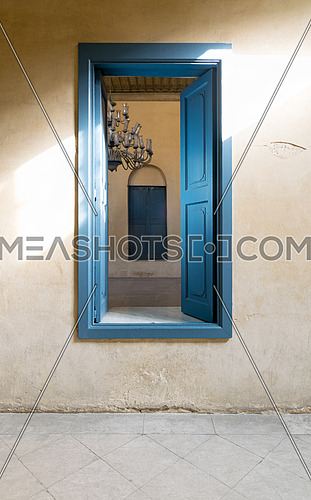 Blue wooden opened window of a old historic building with vintage plaster wall, Medieval Cairo, Egypt